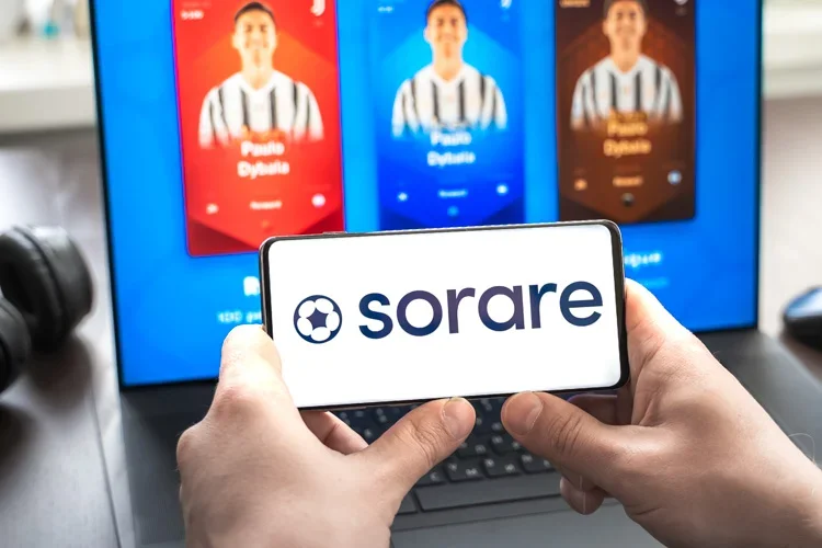 Sorare отображается на фоне размытых карточек с футболистами.