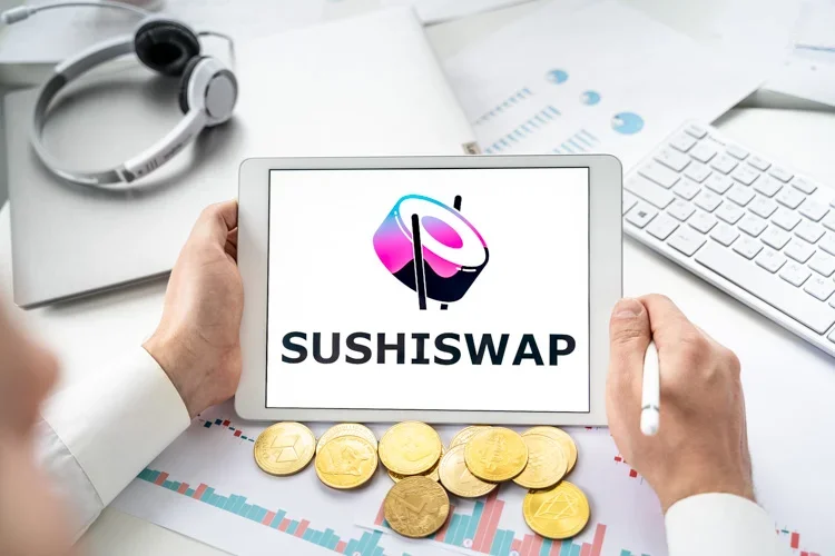 SushiSwap и золотые монетки криптовалют лежат на столе.