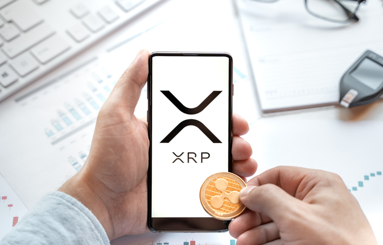Криптовалюта XRP открыта на экране смартфона с монеткой.