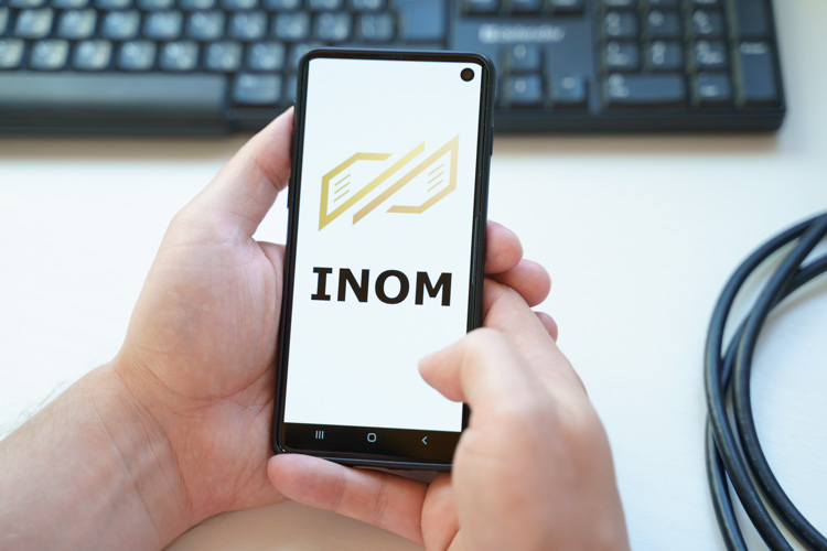 Криптовалюта INOM открыта на экране телефона.