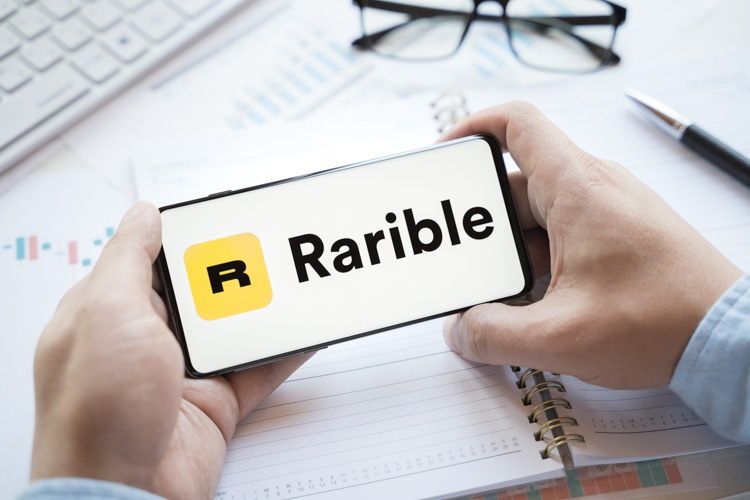 NFT маркетплейс Rarible открыт на экране смартфона.